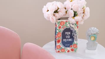 A vase with pink flowers on a white table.