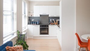 Eine moderne Wohnung mit Wohnzimmer, Küche und Essbereich.