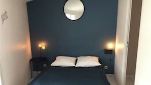 A bedroom with a bed, two bedside tables, and a round mirror on the wall. - LE COURLIS, Residences RE LOCATIONS VANCES VILLA Re (Saint-Clément-des-Baleines)
