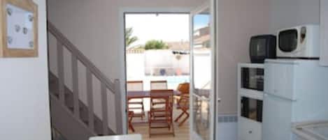 Una cocina compacta con comedor, una escalera y vistas al exterior.