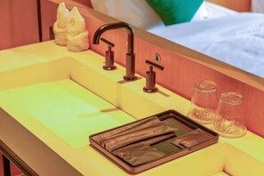 Ein Badezimmer mit Waschbecken, Wasserhahn und Pflegeprodukten.