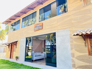 A two-story building with a modern design, featuring large windows and a sign that reads "Pousada Landé".