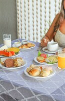 Una mesa de desayuno con platos de comida, un vaso de jugo de naranja y una taza de café.