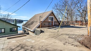 Une maison avec un toit en pente, une terrasse en bois et une vue sur un lac.
