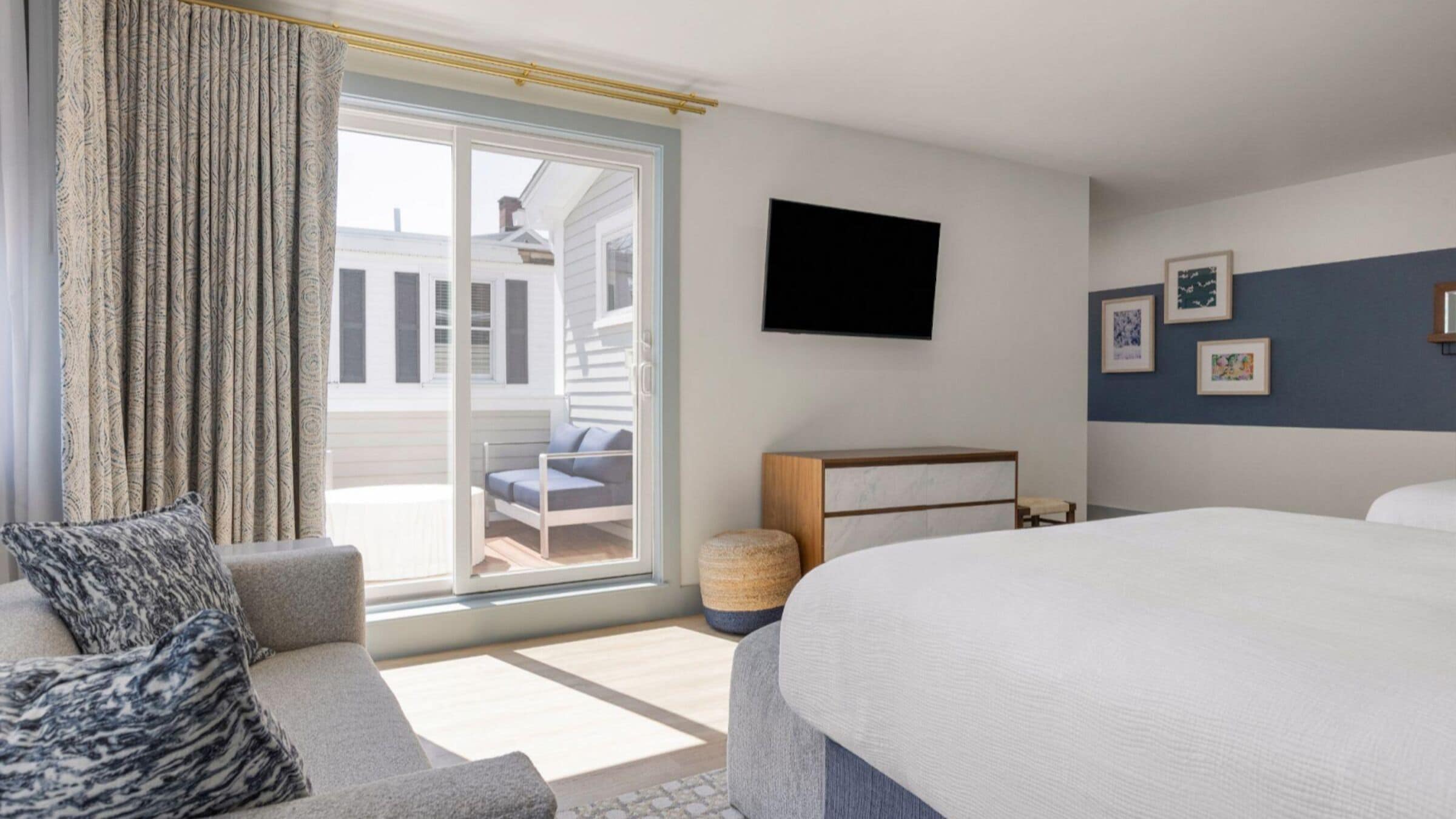 Et hotelværelse med en stor seng, en sofa, et fjernsyn monteret på væggen og udsigt ud