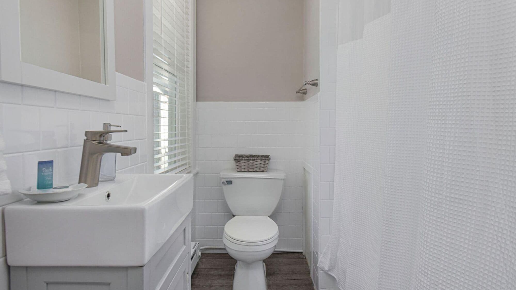 Un baño con un lavabo blanco, un inodoro y una cortina de ducha.