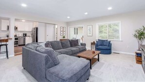 Una sala moderna con un sofá modular, una mesa de centro y un sillón azul.