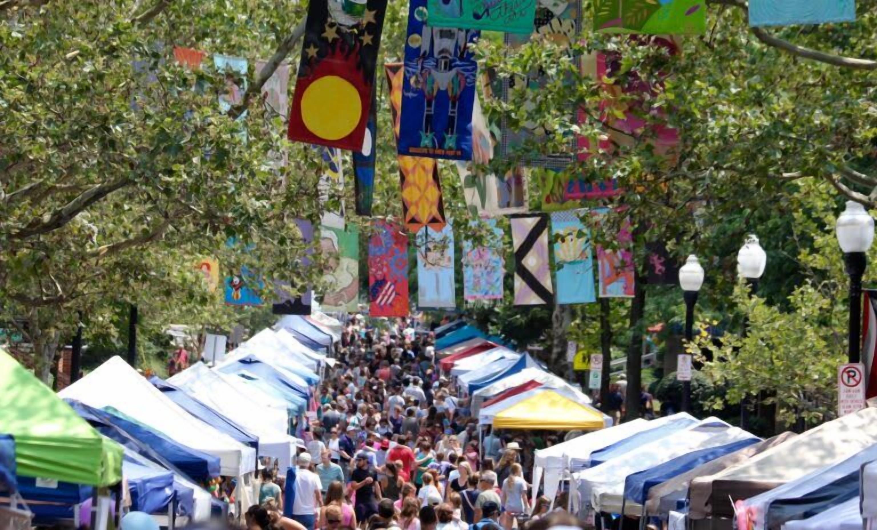 A crowded street with tents and flags.