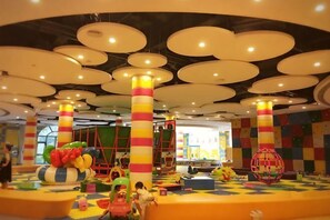 A brightly lit indoor play area with colorful play structures and a checkered floor. - Hengda Hotel (Meishan)