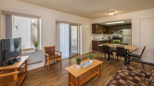 A modern apartment with a living room, dining area, and kitchen. It includes a TV, seating, and a dining table. - Tahiti Inn  (Ocean City)
