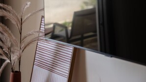 Una ventana con vista a la playa y un cuadro enmarcado apoyado contra ella.