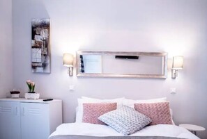 A bedroom with a bed, bedside tables, a dresser, and a wall-mounted mirror. - Lovely, compact quiet flat in the center (Nari's) (Budapest)