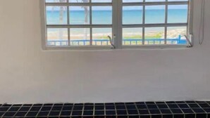 Quarto com uma grande janela com vista para a praia.