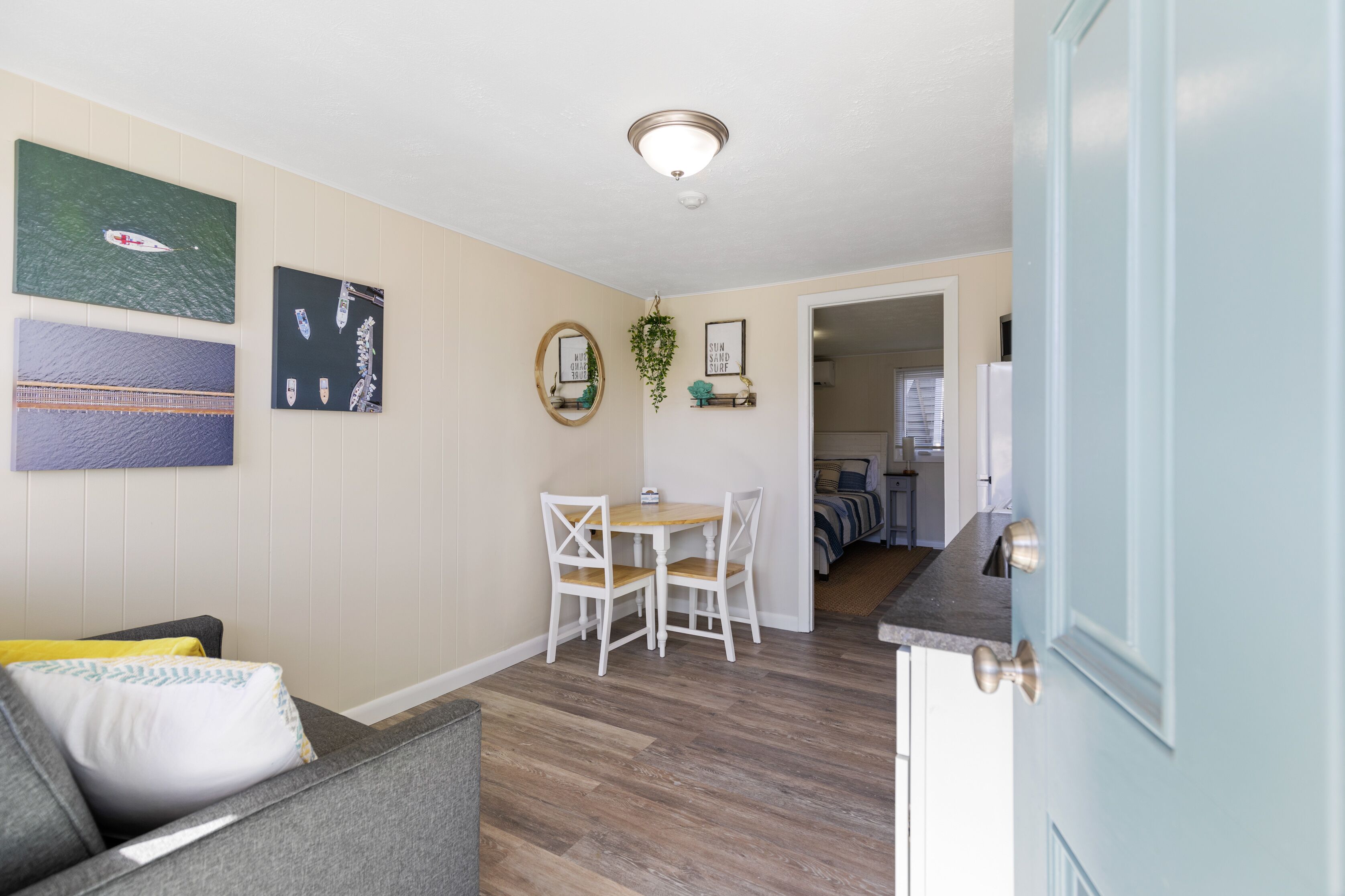 A compact living space with a dining area, a sofa, and a kitchen.