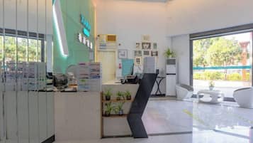 A reception area with a counter, a reception desk, and a seating area with chairs.
