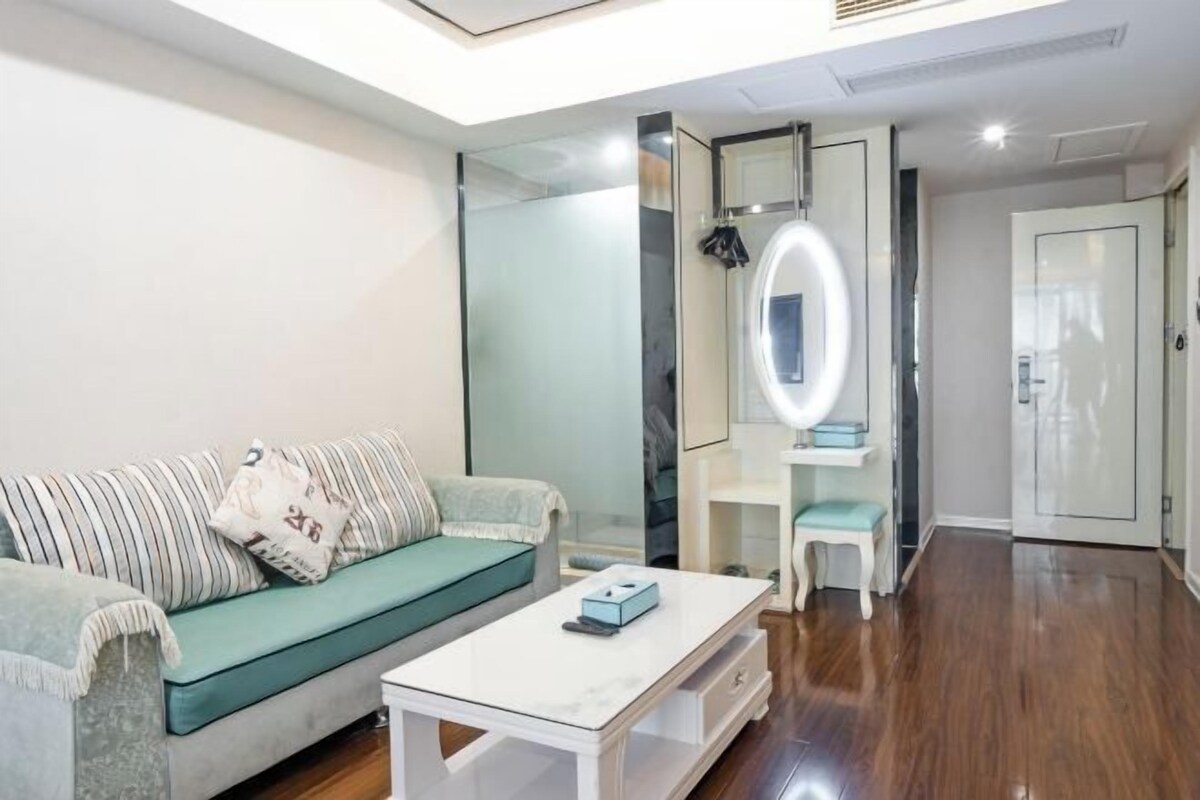 Uma sala de estar moderna com um sofá, uma mesa de centro, um espelho e um guarda-roupa.