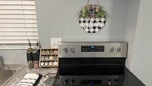A kitchen with a stove, a spice rack, and a 'Welcome' sign. - Charming Home just minutes from Interstate and Mall (Kevil)