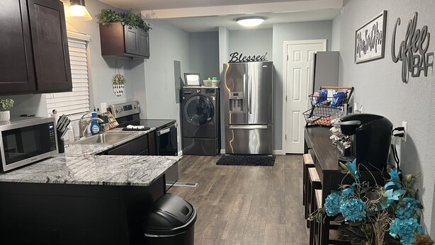 A modern kitchen with a built-in microwave, stainless steel appliances, and a sink. - Charming Home just minutes from Interstate and Mall (Kevil)