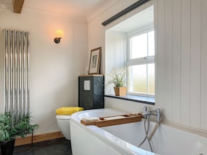 A bathroom with a bathtub, toilet, and a window with a view. - Only 4 miles from Westward Ho. (Littleham, near Bideford)
