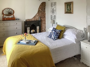 A bedroom with a bed, dresser, nightstand, and a fireplace. - Only 4 miles from Westward Ho. (Littleham, near Bideford)