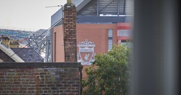 Un edificio de ladrillo con un llamativo letrero del Liverpool Football Club.