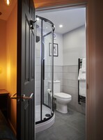 Un bagno moderno con cabina doccia in vetro, un water e un appendi asciugamani.