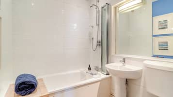 A modern bathroom with a bathtub, a sink, and a shower.