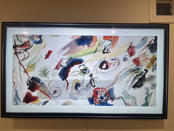 A framed abstract painting with visible text and symbols.
