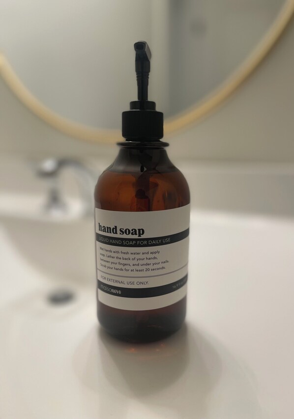 Una botella de jabón de manos sobre un lavabo de baño.