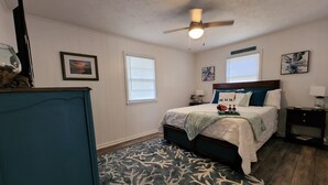 A bedroom with a bed, nightstands, a ceiling fan, and a dresser. - 2 miles to the beach!!  Full renovated home with ICW views (Supply)