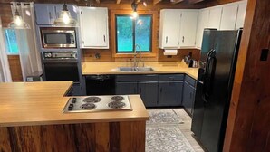 Een moderne keuken met een centraal eiland, inbouwapparatuur en uitzicht op de omgeving.