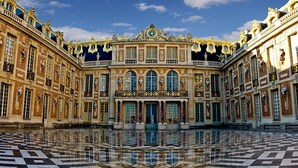 A grand, symmetrical building with a central courtyard, ornate balconies, and a large clock at the top. - 5 minutes to Versailles (Saint-Cyr-l'École)