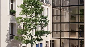 A modern building with large windows, a tree in the courtyard, and a person walking. - 5 minutes to Versailles (Saint-Cyr-l'École)