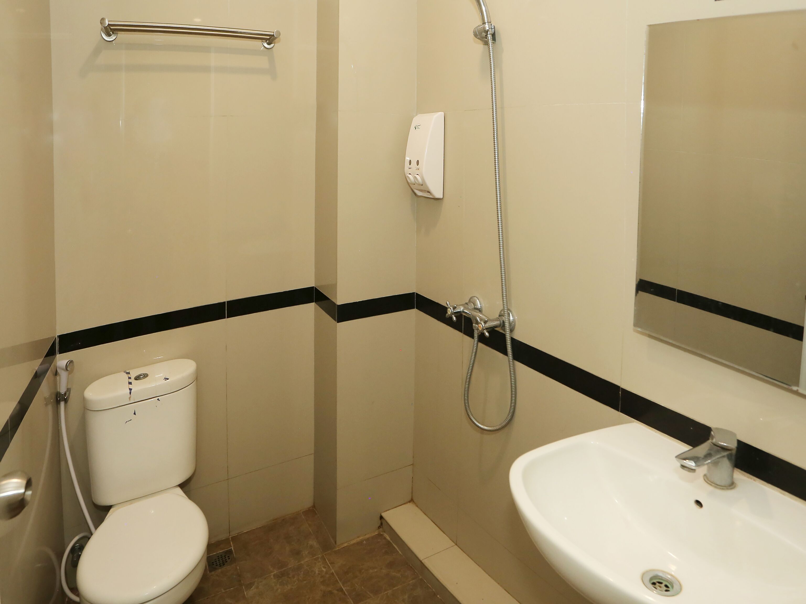 A bathroom with a toilet, a shower, and a sink.