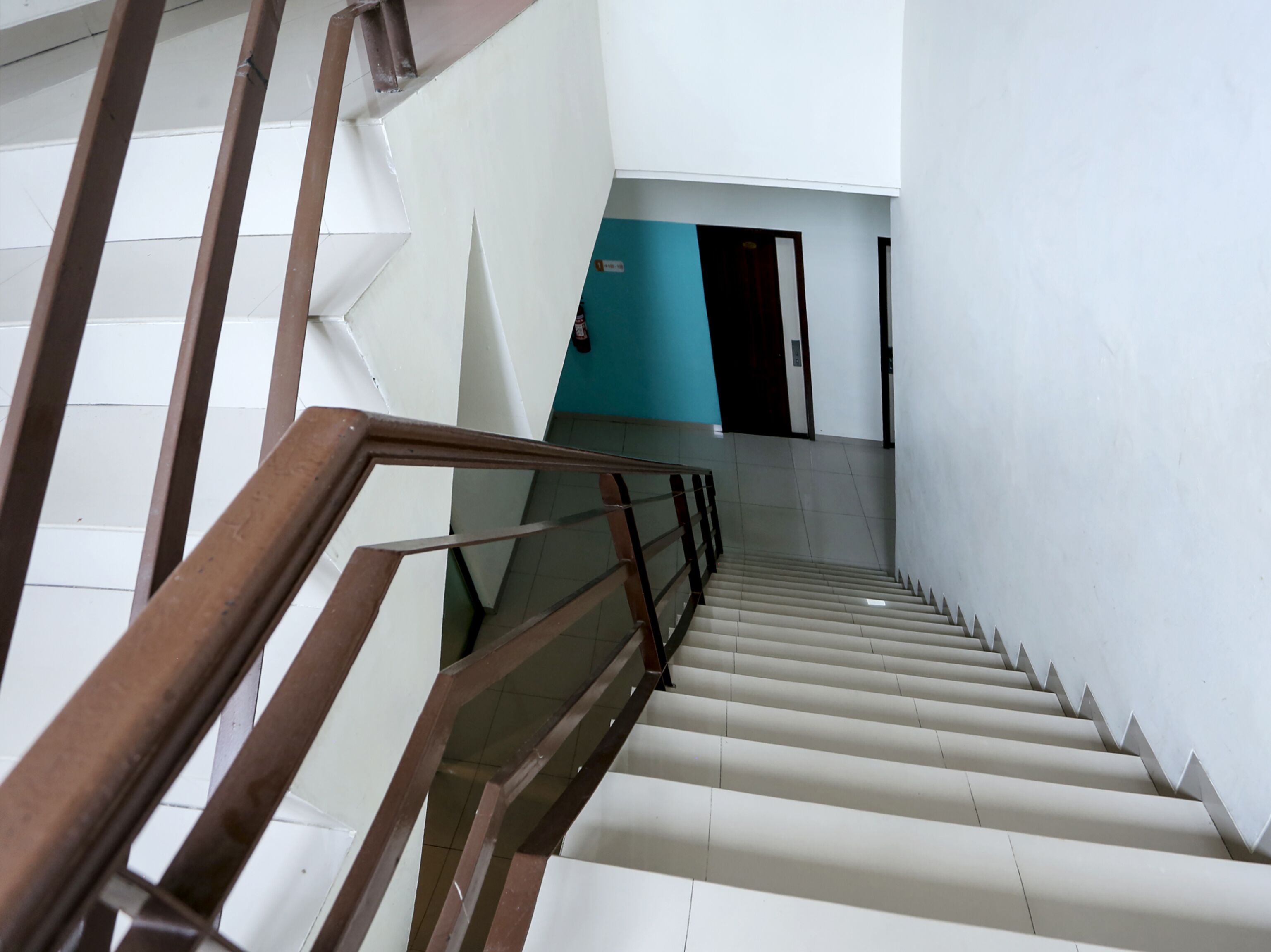 Un escalier avec des rampes en bois et des marches blanches.