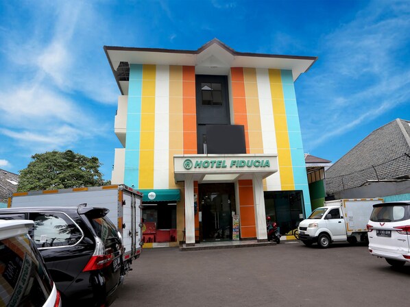 A hotel with a colorful facade and a sign reading "HOTEL FIDUCIA".