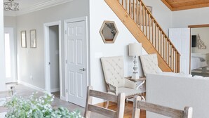 Un vaste espace de vie comprenant un escalier en bois, une table à manger avec des chaises et un canapé.