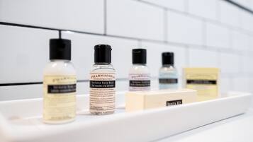 Un estante de baño con diversos artículos de aseo, incluyendo una botella de gel de ducha, una botella de acondicionador y un neceser.