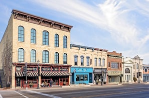 A multi-story building with various storefronts, including a tavern, a pharmacy, and a church.