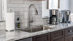 A modern kitchen with a stainless steel sink, a coffee maker, and a soap dispenser. - Beautiful 4-season Mountain Home- New Listing (Wintergreen Resort)