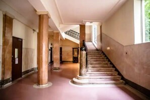 Uma escadaria imponente com degraus de mármore e um corrimão, que leva a um andar superior.
