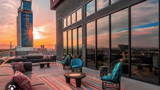 Une terrasse sur le toit au design moderne, comprenant un grand canapé, des fauteuils et une table basse.