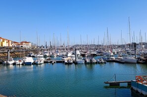 A marina with numerous boats docked, a bridge, and buildings in the background. - Appartement “Mer” – Confort moderne & stationnement à La Chaume (Les Sables-d´Olonne)