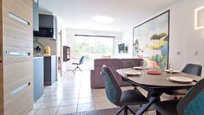 Un comedor con una mesa preparada para cuatro personas, un sofá y un cuadro en la pared.