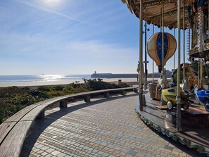 A carousel with horses and a beach in the background. - Front de Mer- 4★  Parking Privé, Wifi  Ménage (Les Sables-d´Olonne)
