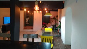 A dining area with a table, chairs, and a hanging light fixture. - Pelourinho, complete house. (Salvador)