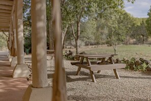 Relax in a serene outdoor setting surrounded by nature, with a picnic table nestled beneath a shaded pavilion.