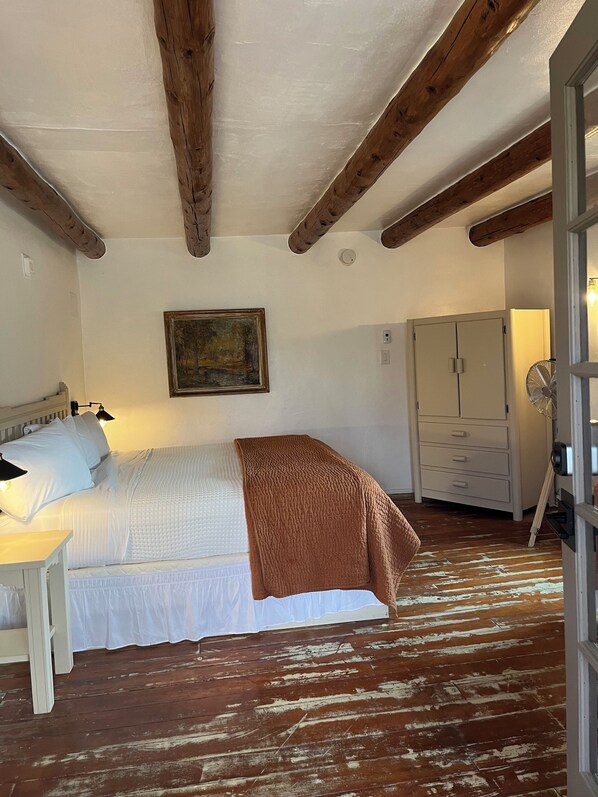 A bedroom with a bed, a nightstand, a wardrobe, and a painting on the wall. - Family room w/ Mountain View - 12 (Taos County)