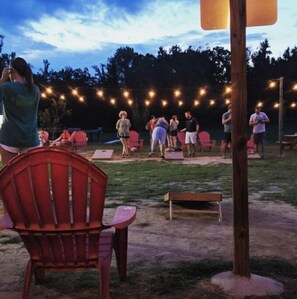 Gather with friends and family in a scenic outdoor setting, surrounded by trees and string lights.