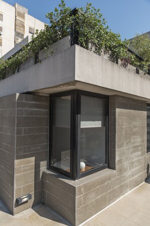 Un bâtiment moderne doté de grandes fenêtres et d’une façade en béton.